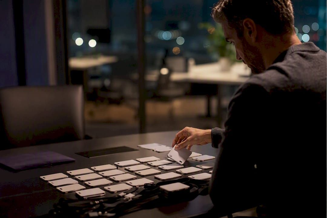 Hand placing AI tool scan badges on a desk