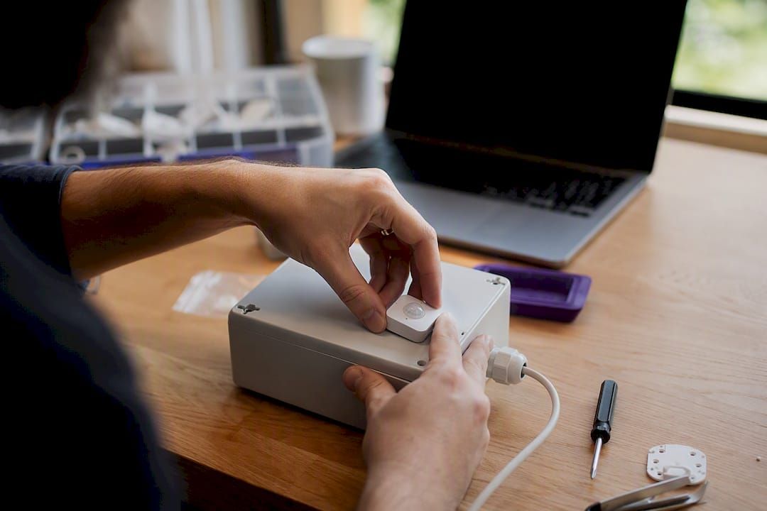 Hands installing smart automation sensor