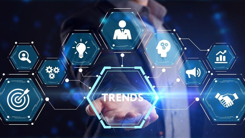 Hand touching a hexagonal interface with the word Trends at its centre, surrounded by business icons
