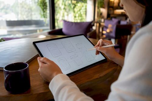 Hands sketching mobile app wireframes