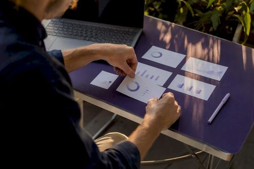 Hands arranging KPI dashboard cards on desk